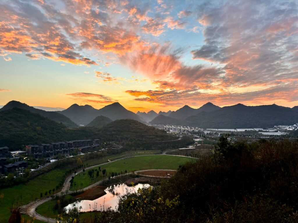 pexels photo 19417435 A stunning sunset above the mountain range and cityscape of Guiyang, China, with vibrant skies and reflective lake.